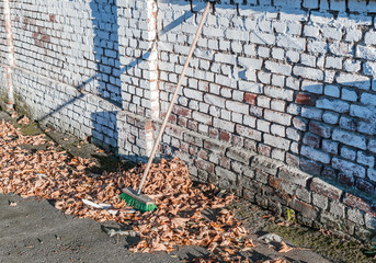 Arbeiten mit dem Besen im Herbst