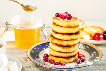 Delicious cottage cheese pancakes with honey and cranberries.