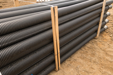 Stacked new PVC pipe on construction site - obrazy, fototapety, plakaty