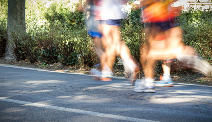 City marathon runners. Long exposure with motion blurred effect. Selective focus on the foreground....