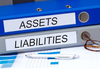 Assets and Liabilities - two binders on desk in the office