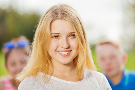 Portrait of beautiful girl, friends on background