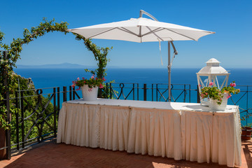 Mediterranean seascape with a table and sun-shade. - 95216297
