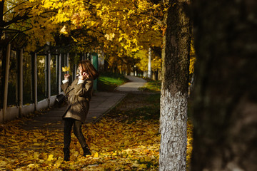 beautiful happy stylish brunette girl on a background of autumn