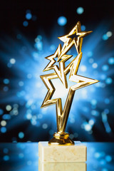 gold stars trophy against shiny sparks background
