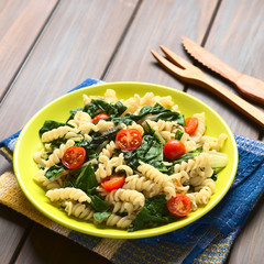 Fusilli pasta with chard leaves (lat. Beta vulgaris) and cherry tomatoes served on plate...