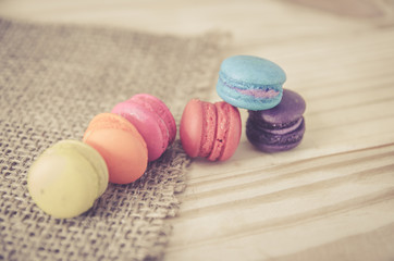 French macaroons on sack with wood background on filter color