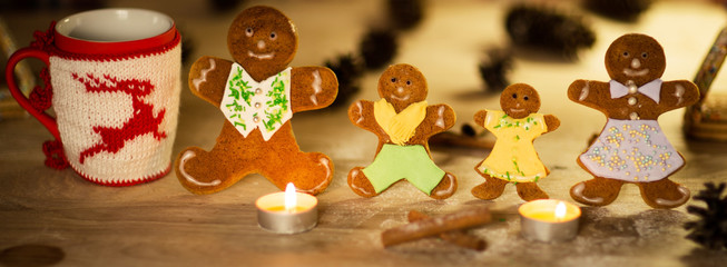 Christmas gingerbread men candles with cinnamon stars Pine twig Christmas ball on a wooden floor