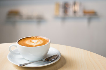 Hot art Latte Coffee in a cup on wooden table and Coffee shop bl