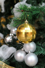 White and yellow christmas tree ball ornaments on tree