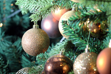 Golden christmas tree ball ornaments on tree