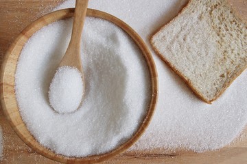 white sugar in wood spoon
