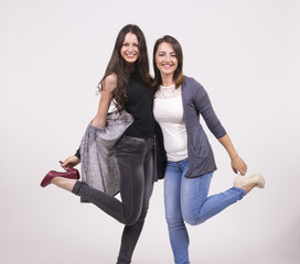 Obraz premium Two girls having fun in studio, white background
