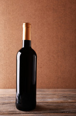 Fototapeta na wymiar Bottle of red wine on wooden table