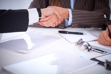 Business handshak  sitting at the desk on office background, copy space area at the left upper corner