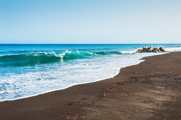 Beautiful beach with turquoise water and black volcanic sand