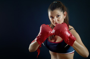 Portrait of beautiful sport girl with boxing gloves looking at y