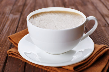 Cup of coffee on brown napkin closeup