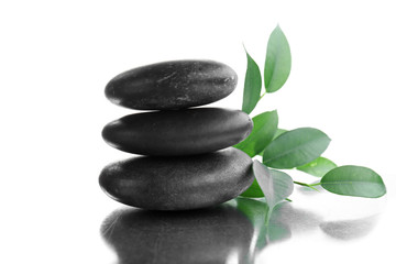 Fototapeta na wymiar Stack of stones and a green flower, isolated on white. Spa relaxation concept