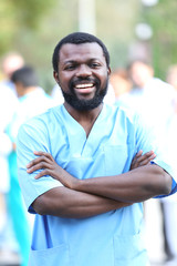 Portrait of an handsome smiling doctor on blurred background