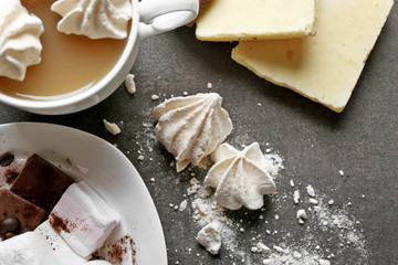 Cup of coffee and sweets on black wooden background