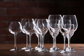 Empty wine glasses on a table on a brick wall background