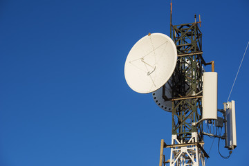 Telecommunications tower at sunrise and blue sky.