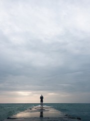 lonely man silhouette on the old sea pier