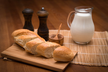 Хлеб, молоко, специи на столе на деревянной салфетке