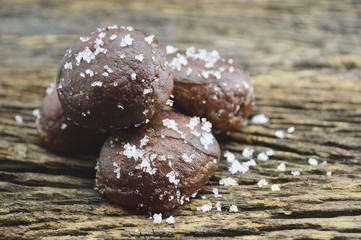 Small chocolate doughnuts on old wooden background