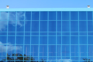 Obraz premium Part of modern building with blue windows with reflection 