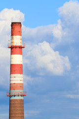 Tall chimney red and white pipe of modern plant and blue sky