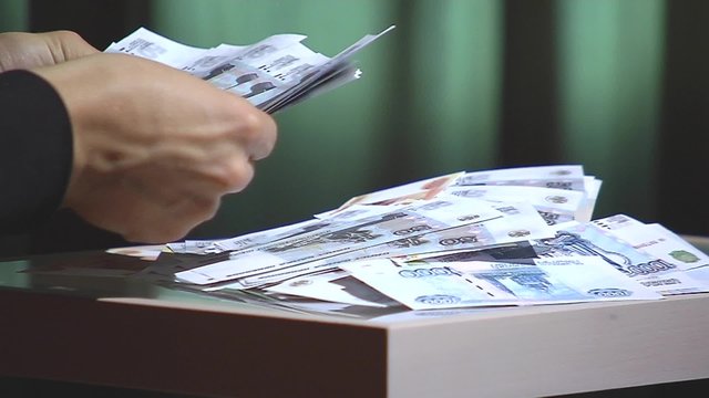Men's hand calculate with reference rubles on the table.