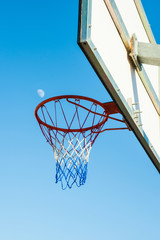 Naklejka premium Aro de una canasta de baloncesto con la luna de fondo