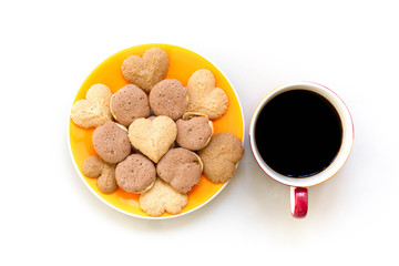Chocolate cookies and butter cookies on white dish with black coffee
