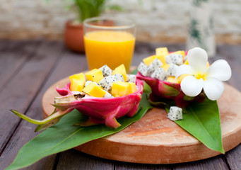 Tropical fruit salad in pitahaya, dragon bowls with mango juice.