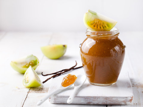 Green tomatoes jam with vanilla pods in a glass jar 