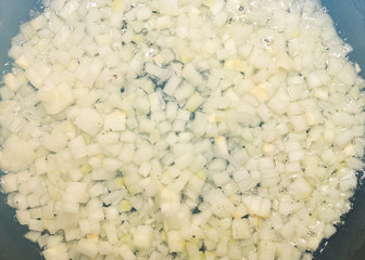 Top view of sauteed onions in skillet with smoke