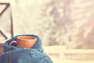 A cup with a hot drink on the background of the winter forest