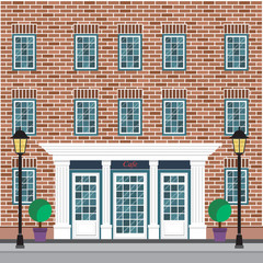 Facade of the building with cafe on the ground floor. The brick facade of the building with detailed windows.