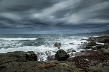 Rough seas and dark clouds over Sardinian coastline