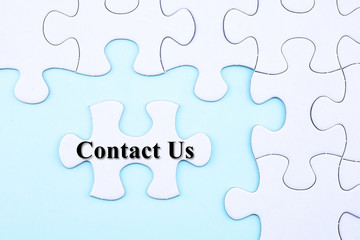 Puzzle written word Contact Us on blue background