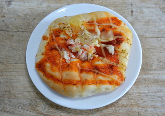 pizza bread topping imitation crab on wooden chop block