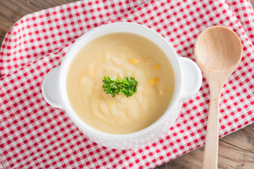 Corn cream soup in white bowl. Top view.