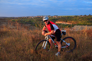 Obraz premium young adult cyclist riding mountain bike in the countryside