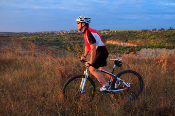 young adult cyclist riding mountain bike in the countryside