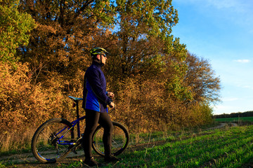 Naklejka premium young adult cyclist riding mountain bike in the countryside