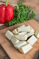 Slice of purple eggplant on wood cutting board. Selective focus.