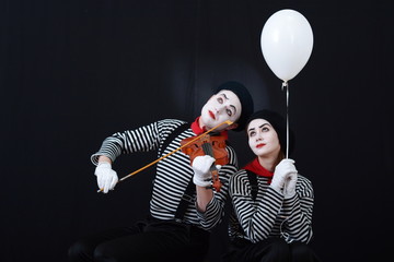a guy and a girl mimes playing the violin