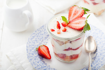 Strawberry tiramisu, trifle, custard dessert with mint leaves 